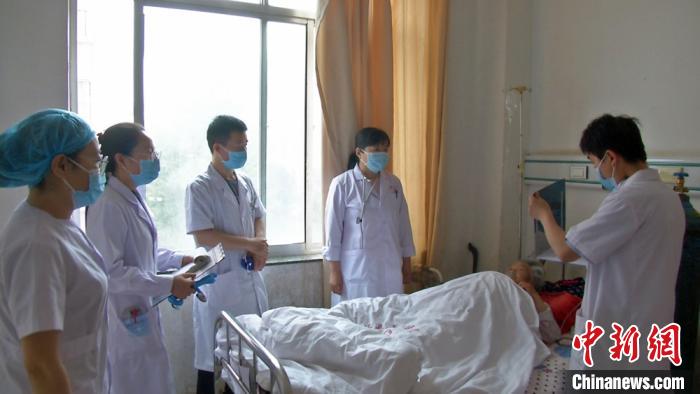 天津医生李汶泽(右二)在病房为患者指导诊断病情，同时为年轻医生传授相关经验。 李文 摄