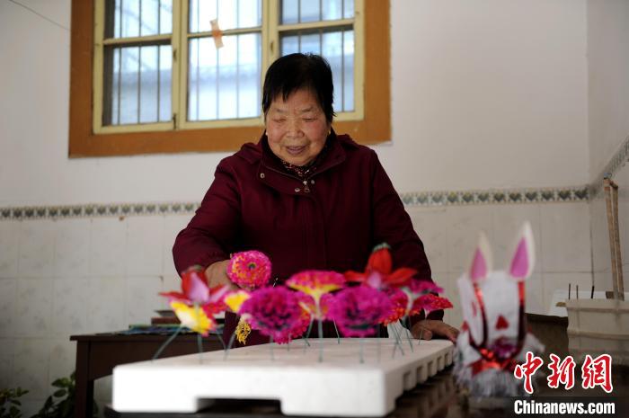 图为王蒲芳将做好的纸花固定在模具上。 高铖 摄
